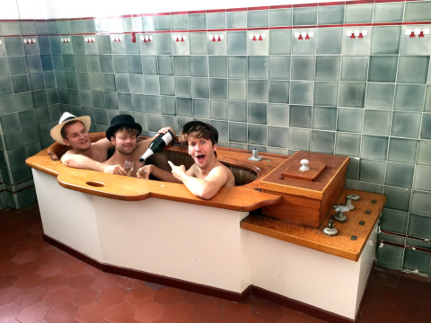 Philip Ritter, Julian Walleck und Robert Nippoldt trinken Champagner in einer Badewanne aus den 1920er Jahren